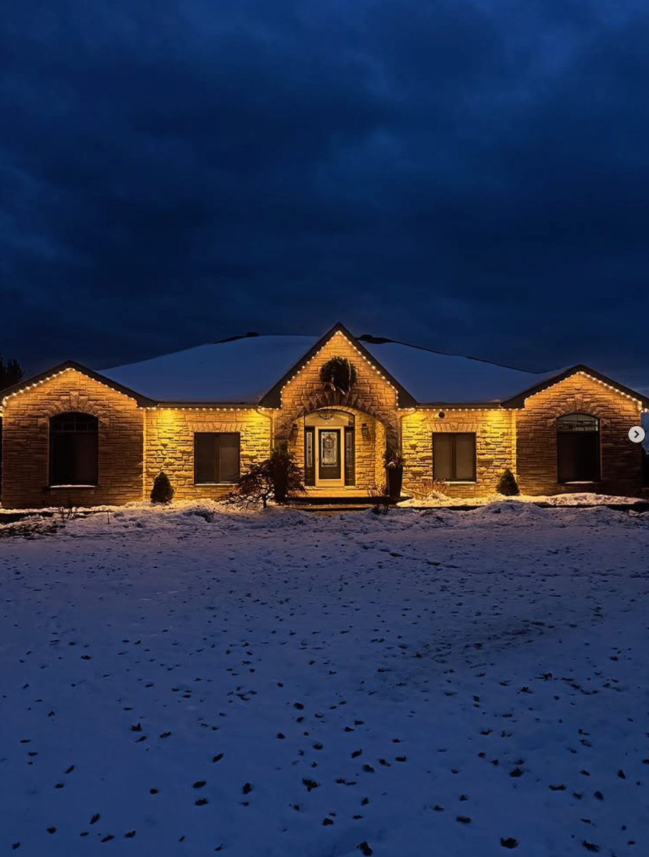 Bungalow with warm-white permanent lighting against a twilight winter sky