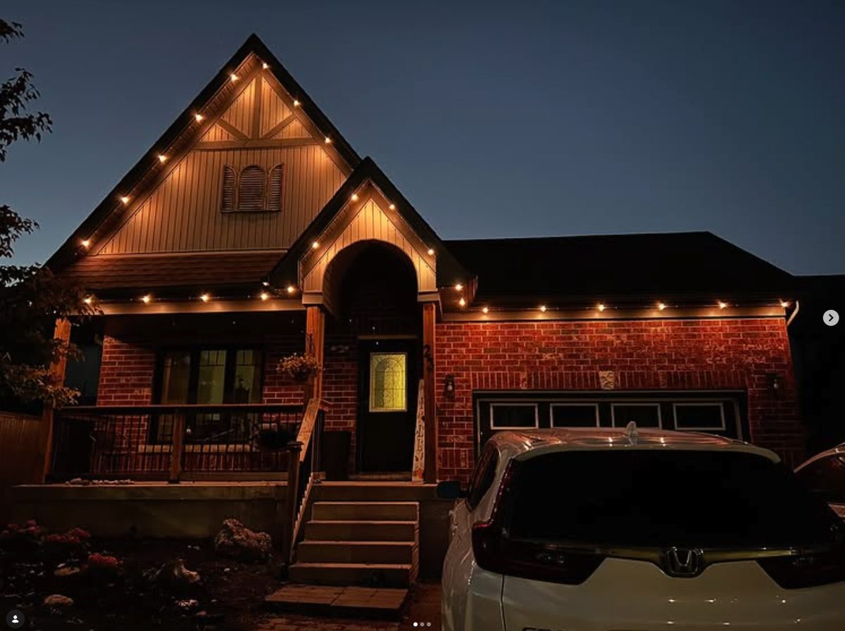 Brick home with warm-white permanent lighting along the roofline